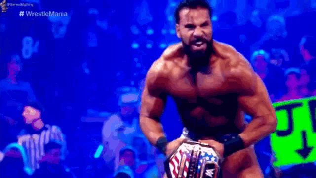 a shirtless wrestler is holding a wrestling championship belt