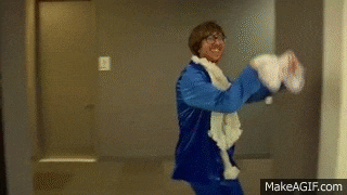 a man in a blue suit is standing in a hallway holding a towel .