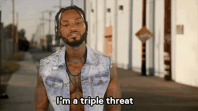 a shirtless man says i 'm a triple threat in front of a building
