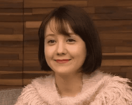 the woman is wearing a pink sweater and red lipstick .