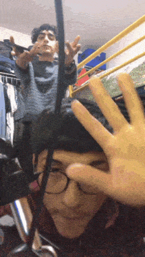 a man with glasses is making a peace sign