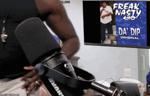 a shure microphone is in front of a screen that says freak nasty da ' dip original