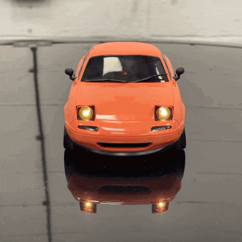 an orange toy car is sitting on a black table