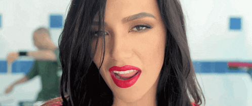 a close up of a woman 's face with red lipstick on