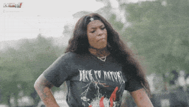 a woman wearing a black back to nature shirt
