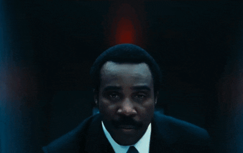 a red light is shining on a door in a dark hallway