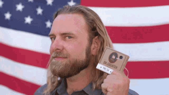 a man with a beard is holding up a card that says dr. squatch