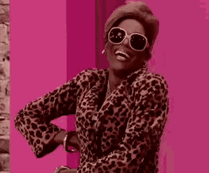 a woman is wearing a leopard print coat and sunglasses .