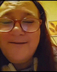 a woman wearing glasses is making a face with her eyes closed