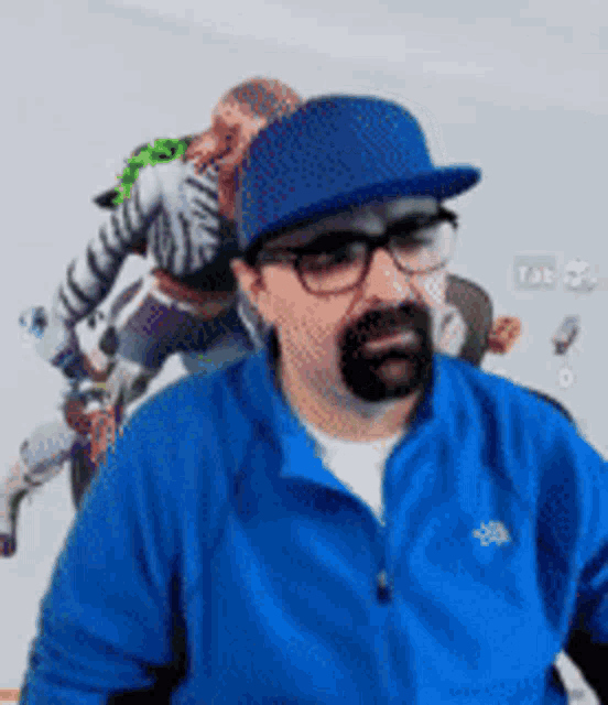 a man with glasses and a beard wearing a blue jacket