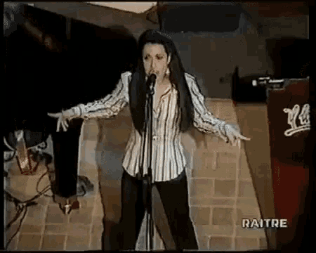 a woman singing into a microphone with the word raitre on the bottom of the screen