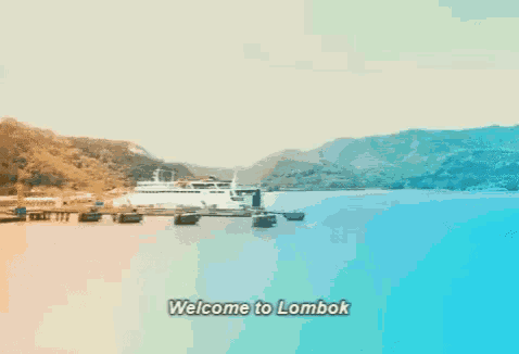 a welcome to lombok sign is displayed in front of a body of water with mountains in the background