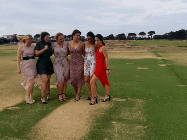 a group of women standing on a golf course