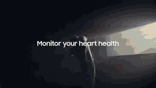 a man is standing in a dark room with the words monitor your heart health written above him