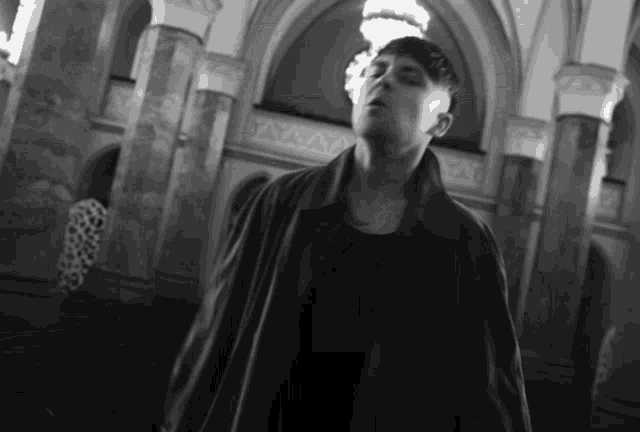 a black and white photo of a man standing in a room