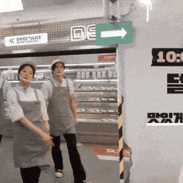 two people wearing aprons and masks are standing in front of a sign that says sweetslice