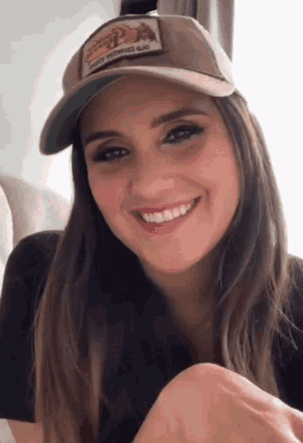 a woman wearing a hat with a patch that says california on it