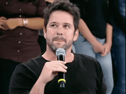 a man in a black shirt is holding a microphone