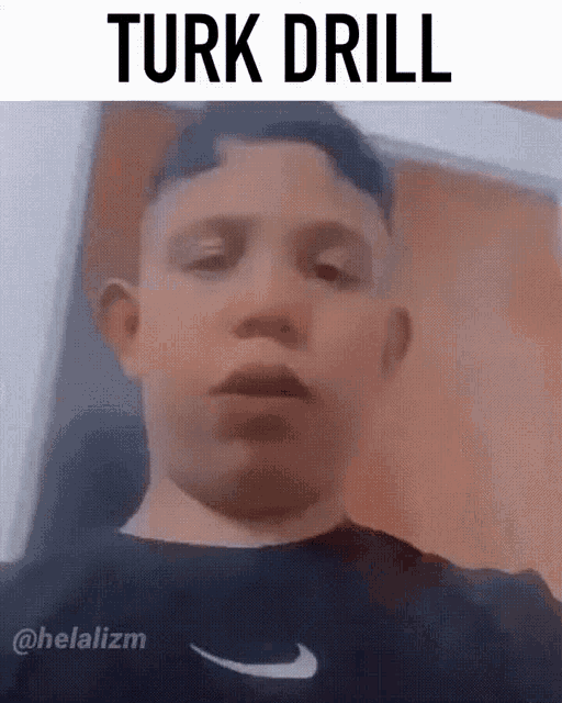 a young boy is wearing a black nike shirt and making a funny face