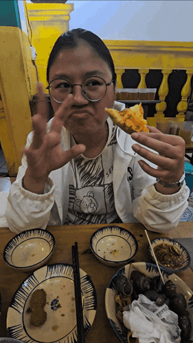 a woman wearing glasses and a shirt with a teddy bear on it eating food