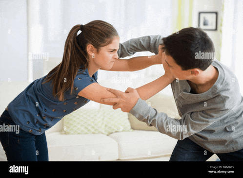a boy and a girl are wrestling in the living room