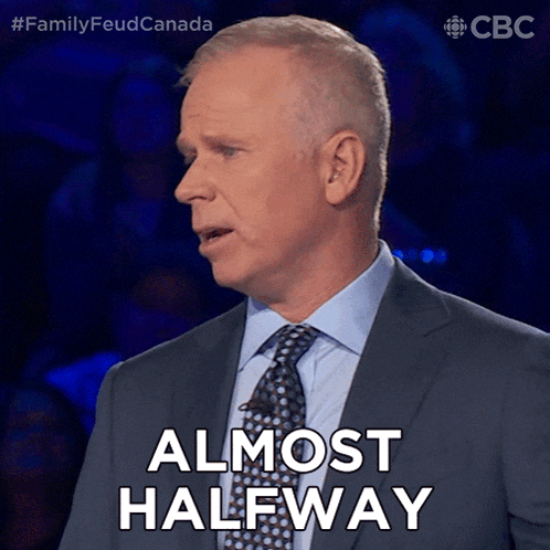 a man in a suit and tie says " almost halfway " in front of a blue background