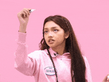 a girl in a pink jacket drawing a triangle with the word philippines written on it