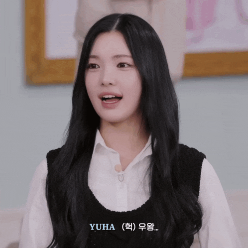 a girl with long black hair is wearing a white shirt and a black vest and the name yuha is on the bottom