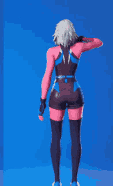 a woman in a pink and blue outfit is dancing in front of a blue wall .