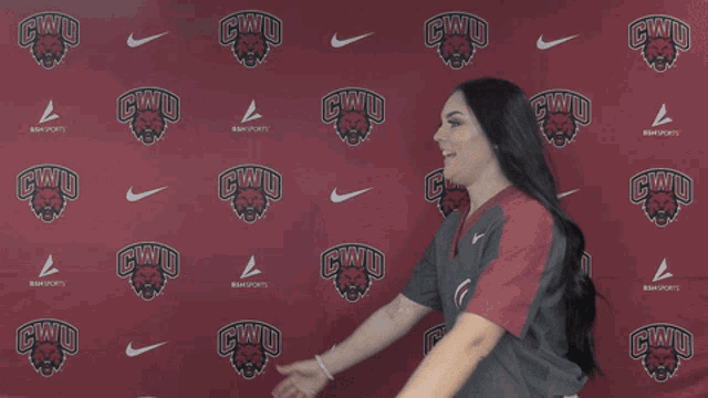 two women hugging each other in front of a cwu banner