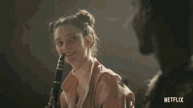 a woman playing a clarinet with a netflix logo on the bottom