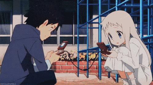a boy and a girl are playing a video game and the girl is looking at her phone