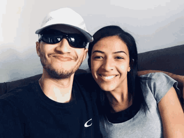 a man and a woman are posing for a picture with the man wearing a nike shirt