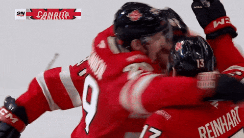 two hockey players are hugging each other and one of them has reinhart on his jersey