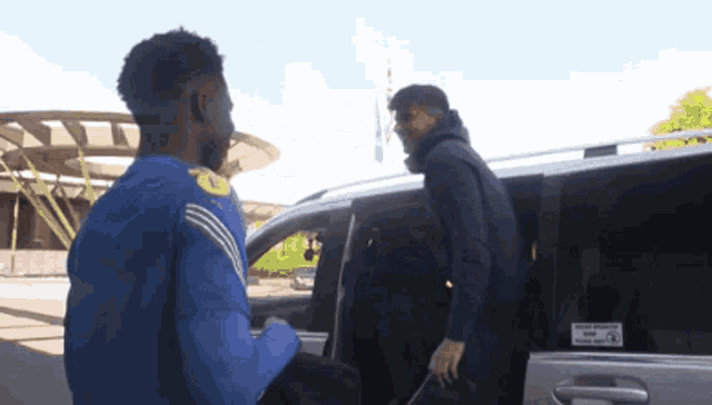 a man in a blue shirt is getting out of a car with a sticker on the door that says your journey