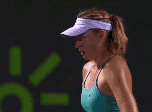 a woman wearing a visor and a green tank top