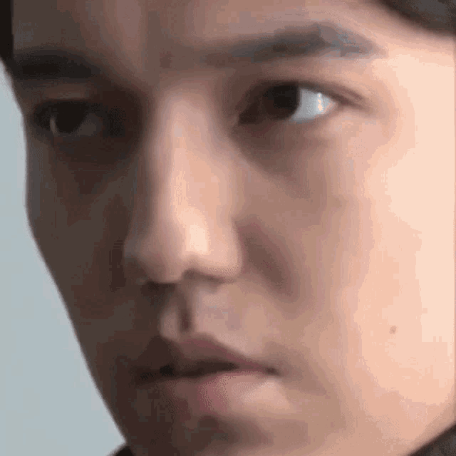 a close up of a young man 's face with his mouth open and his eyes closed .