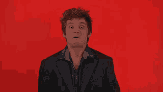 a man in a suit is making a face with his mouth open
