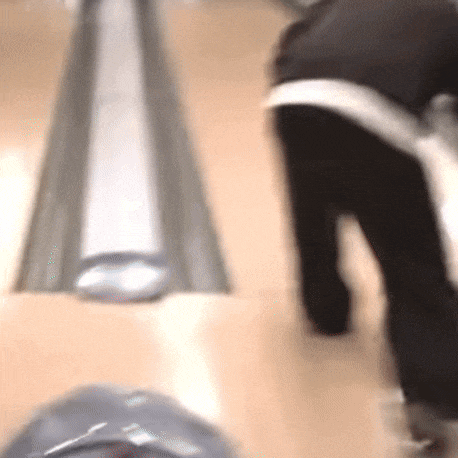 a blurry picture of a person bowling on a bowling alley .
