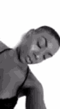 a black and white photo of a woman with her eyes closed and her head on her shoulder .