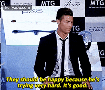 a man in a suit and tie is saying they should be happy because he 's trying hard .