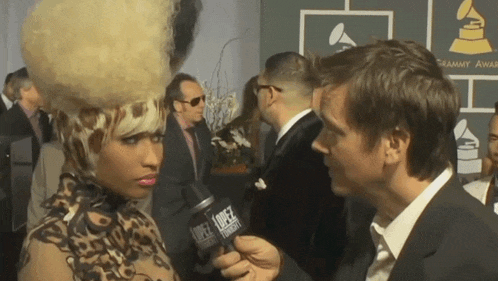 a woman is being interviewed by a man in front of a sign that says grammy
