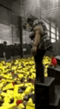 a person is standing in a room filled with lots of yellow toys .