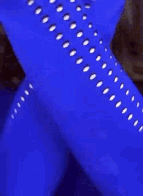 a woman in a blue crop top and blue leggings is covering her face .