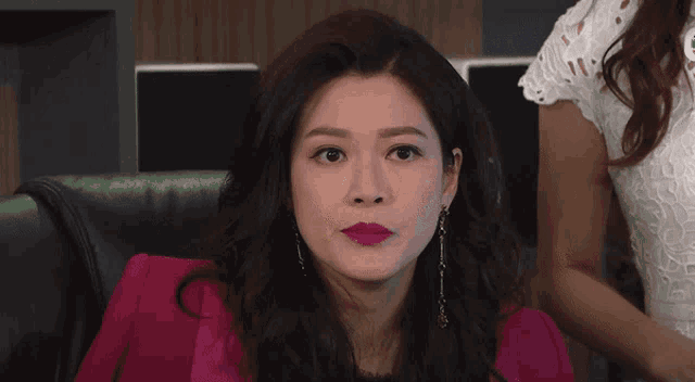 a woman in a pink jacket is looking at something