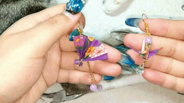 a person is holding a pair of earrings in their hand