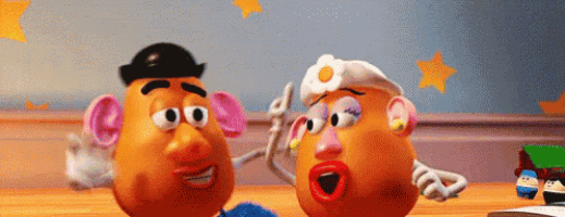 mr. potato head and mrs. potato head from toy story are sitting on a wooden table .