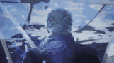 a man is sitting in a cockpit of a plane looking out the window .