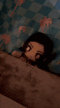 a stuffed doll is laying on a bed with palm trees on it