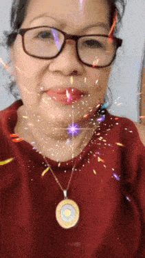 a woman wearing glasses and a necklace with a pendant